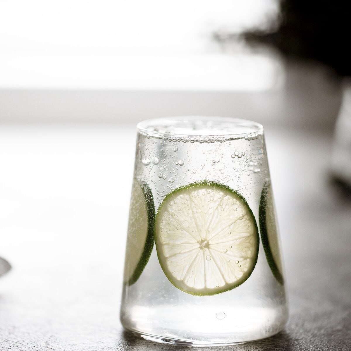 glass of fresh drinking water and a lime. or Alcoholic Gin and Tonic